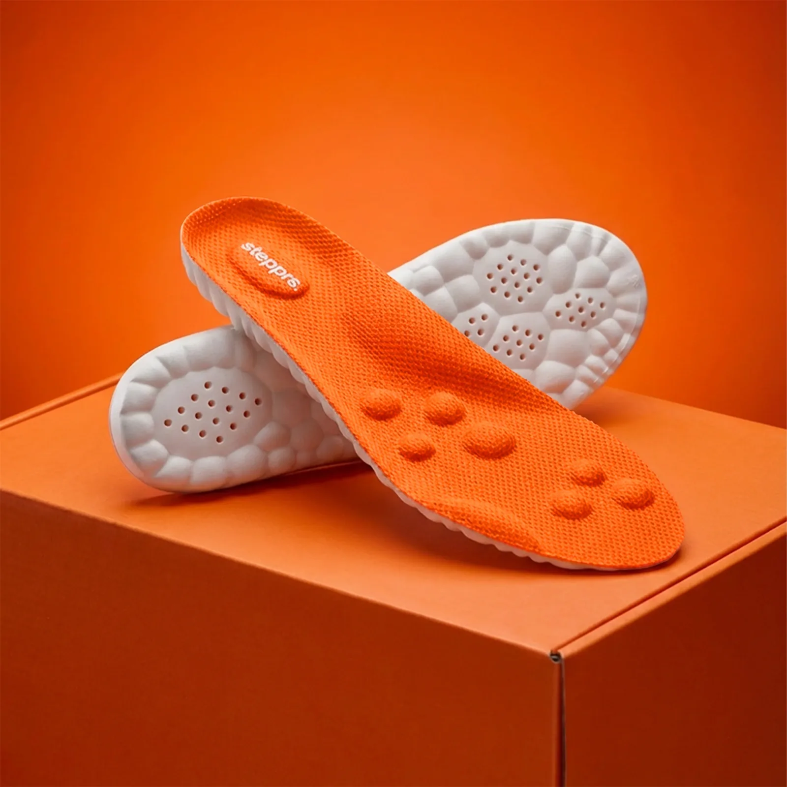 Stepprs Massage Insoles featuring textured orange surface and supportive cushioning design